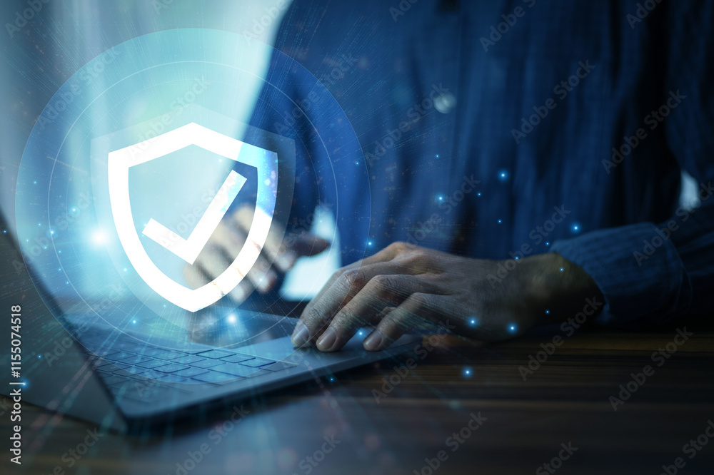 Man working on a laptop with advanced cyber security shield, ensuring the protection of sensitive data and securing the digital environment against potential threats.