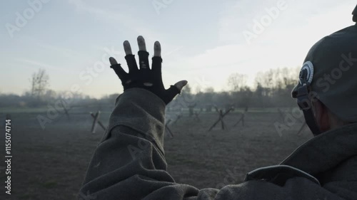WWI scene of a German soldier emerging from a trench at dusk, hands raised, surrendering in no man's land. The dim lighting evokes a somber, tense atmosphere.