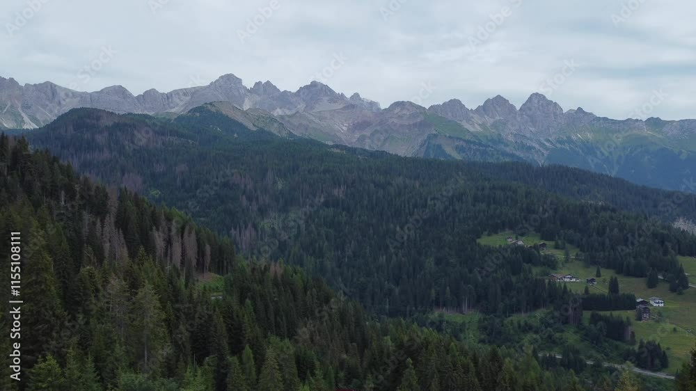 Stunning aerial view of the Dolomites mountain range near Falcade, showcasing lush forests, green meadows, and rugged peaks. Stunning aerial view of the Dolomites mountain range near Falcade, showcasing lush forests, green meadows, and rugged peaks.