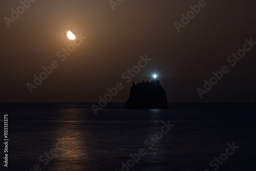 Atmospheric view of Strombolicchio and Calabria coastline under moonlight photo