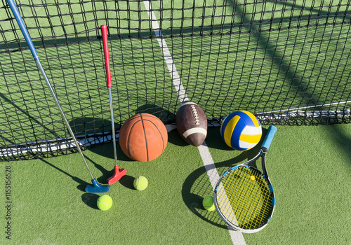 A variety of sports equipment including an american football, a soccer ball, a tennis racket, a tennis ball, and a basketball photo