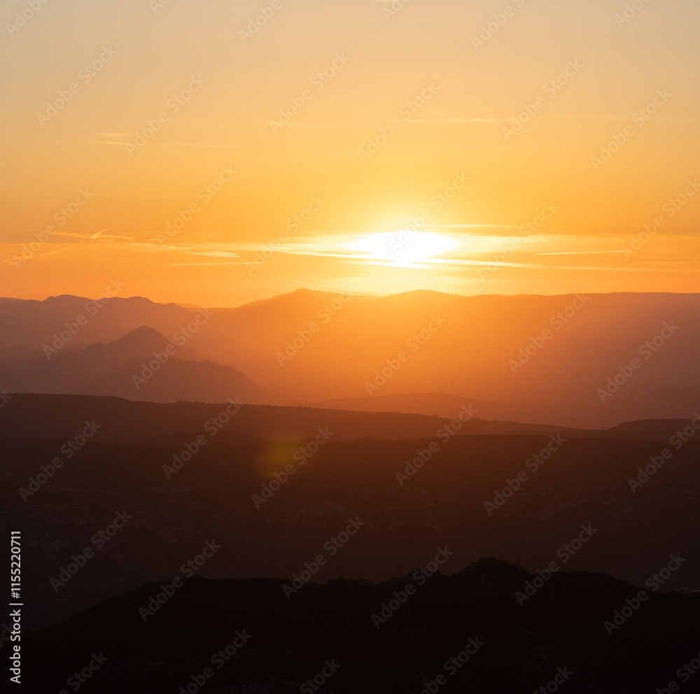 Atardecer entre las montañas con tonos naranjas Atardecer entre las montañas con tonos naranjas