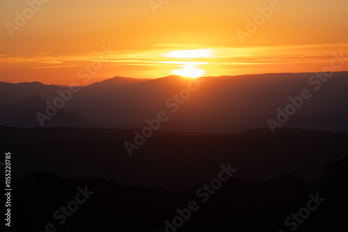 Atardecer entre las montañas con tonos naranjas