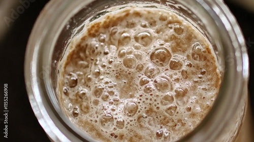 Close-up of bubbling fermentation in a glass jar.