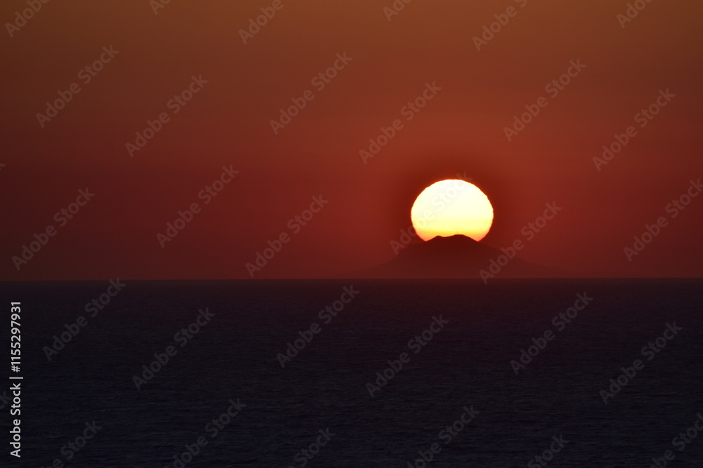 Sunset over the ocean with the sun setting behind a distant island, casting a warm orange glow across the sky and calm water, creating a dramatic and serene seascape
Sunset over the ocean with the sun setting behind a distant island, casting a warm orange glow across the sky and calm water, creating a dramatic and serene seascape