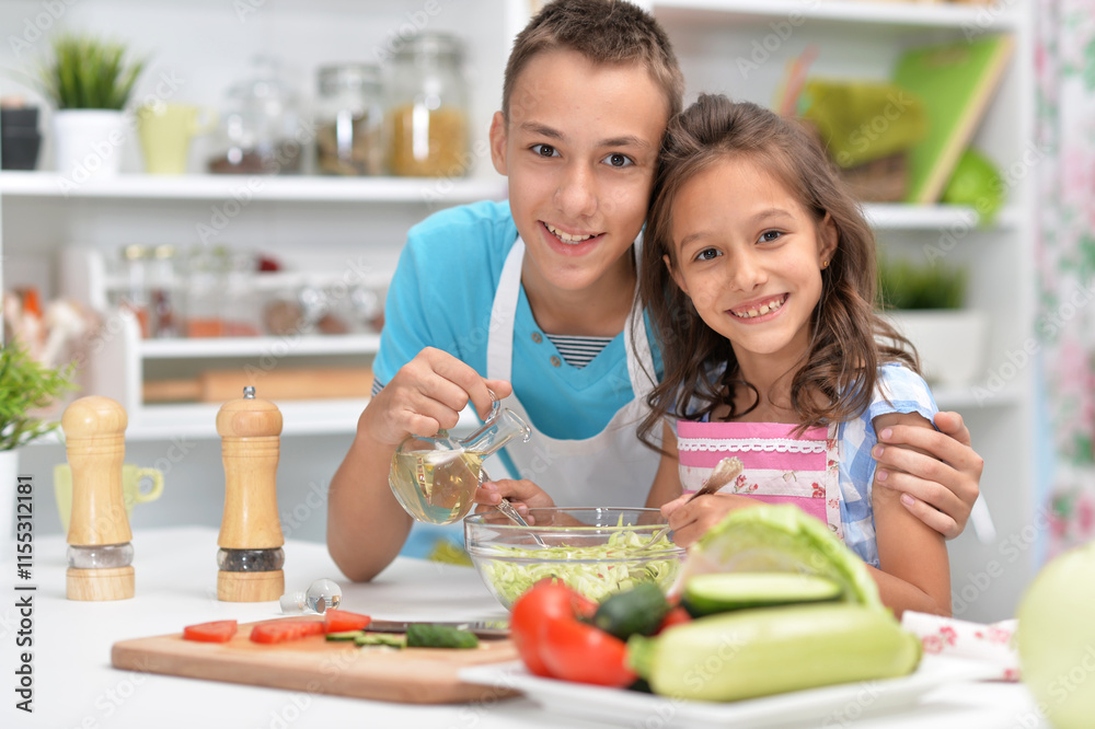 Cute little brother and sister preparing salad together at kitchen Cute little brother and sister preparing salad together at kitchen