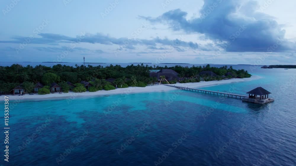 Top view of the sunset over an island in the ocean. Large dark clouds with a pink tinge. Turquoise ocean water, white sand of the beach. Green palm trees and trees. Maldives. Water is like a mirror Top view of the sunset over an island in the ocean. Large dark clouds with a pink tinge. Turquoise ocean water, white sand of the beach. Green palm trees and trees. Maldives. Water is like a mirror