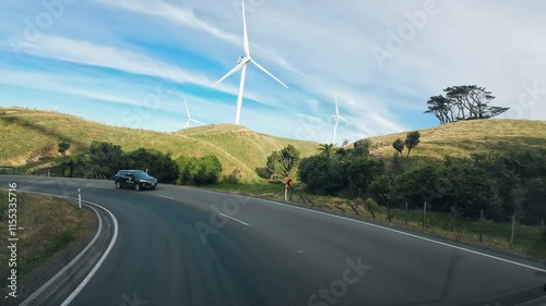 Road trip driving along scenic highway with the forest and wind turbines spinning on green hill in New Zealand photo