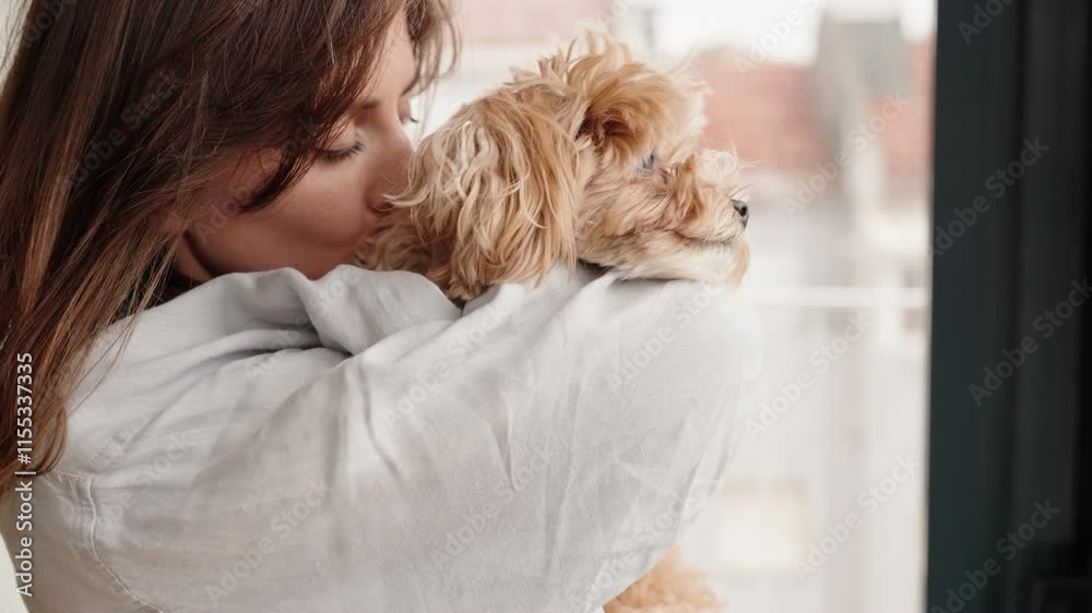 An affectionate moment as an owner lovingly holds and hugs their cute dog, exemplifying a special human-animal bond.