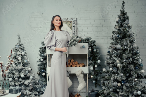 Elegant Woman in Grey Dress with Festive Greenery. photo