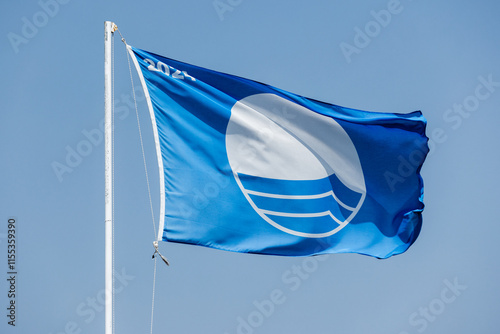 Blue Flag beach. Closeup photo of a flag waving under blue sky