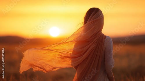 Captured from behind, a woman wrapped in a shawl looks into a sun-lit horizon, encapsulating serenity and introspection under the sun’s radiant glow.