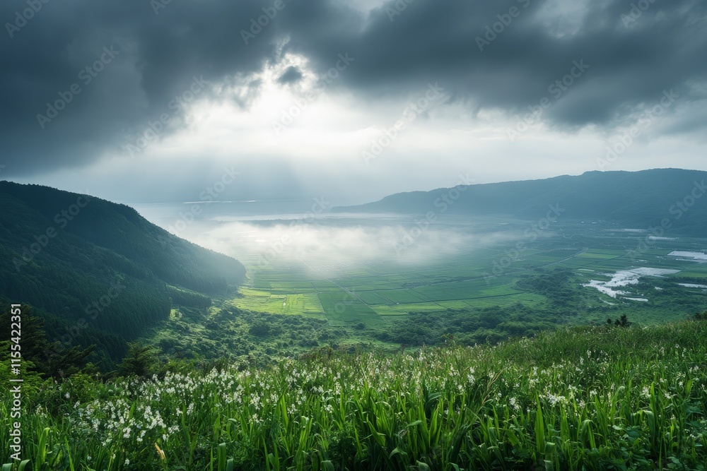 Fototapeta premium Spectacular view of an expansive green valley with sunlight breaking through dramatic clouds, revealing rolling hills, cultivated fields, and a distant mountain range.