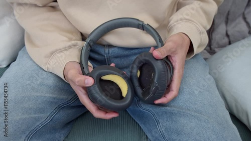 man holding old worn headphones