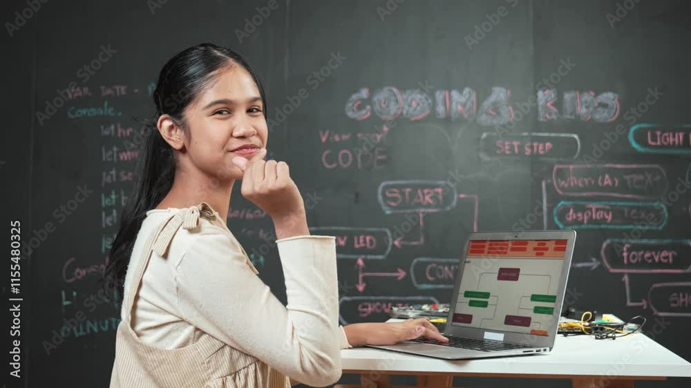 Smart girl using laptop coding or programming system at blackboard. Happy high school student working on laptop while turnaround and showing miniheart and looking at camera at STEM class. Edification Smart girl using laptop coding or programming system at blackboard. Happy high school student working on laptop while turnaround and showing miniheart and looking at camera at STEM class. Edification
