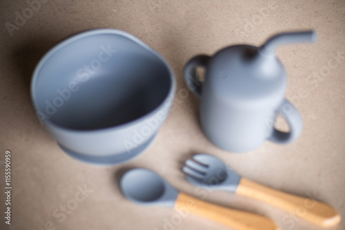 Blurred photo of gray silicone baby feeding utensils, the first feeding utensils for toddlers. Baby feeding utensils