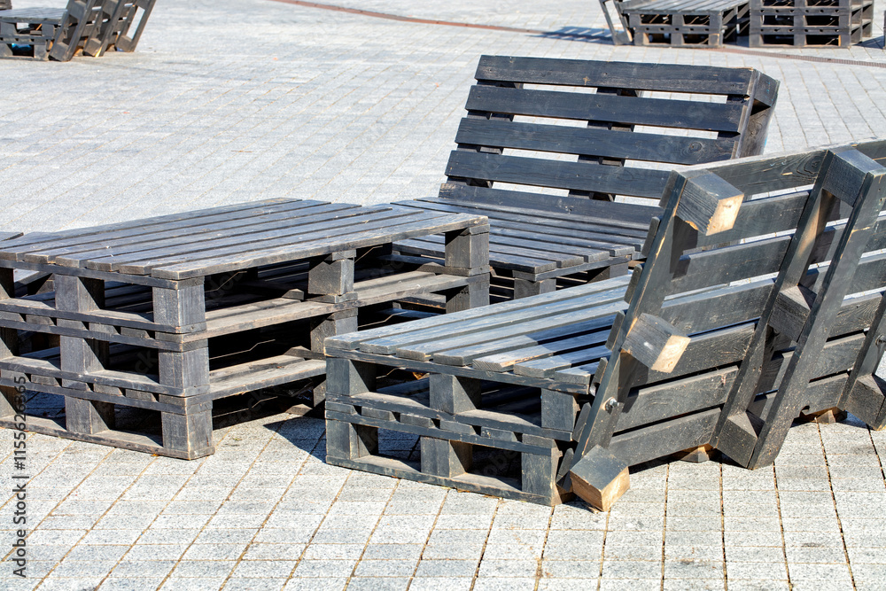 Creative outdoor seating arrangement made of wooden pallets in a sunny urban environment