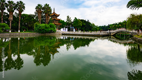 Buddhist temple with a bridge over the lake in Yunnan Province photo