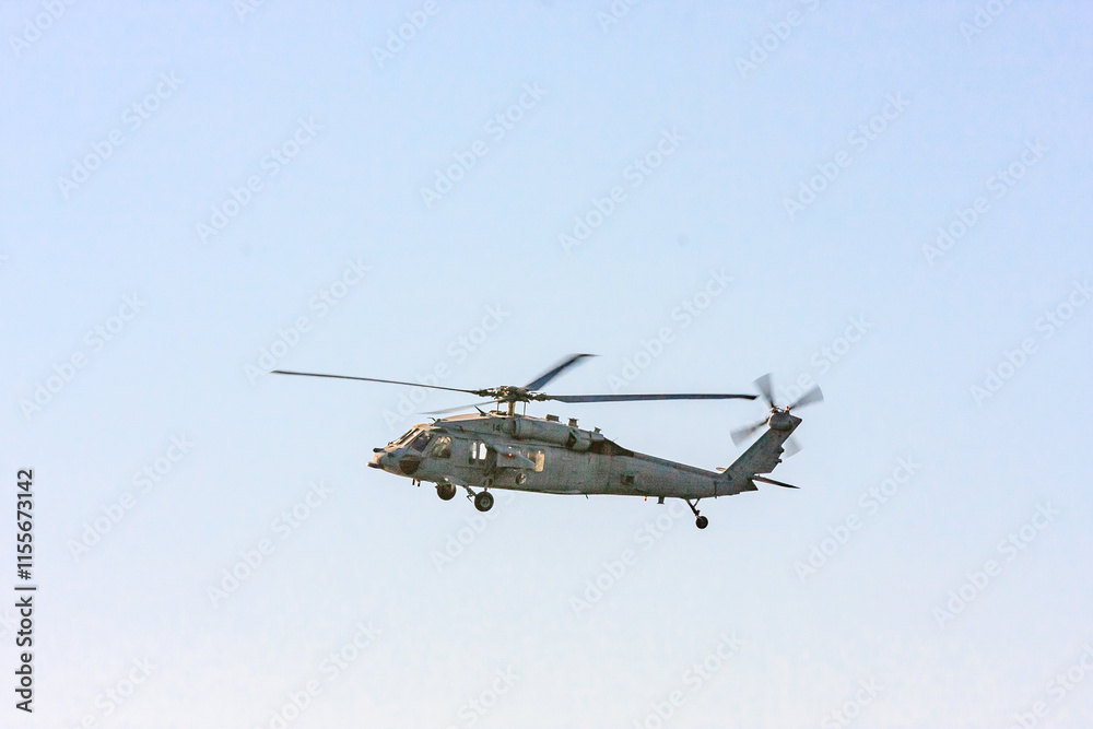 A military helicopter is flying in the sky A military helicopter is flying in the sky