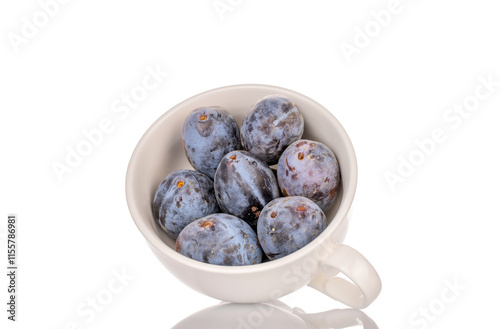 Black ripe plums with home accessories isolated on white background, close-up. photo