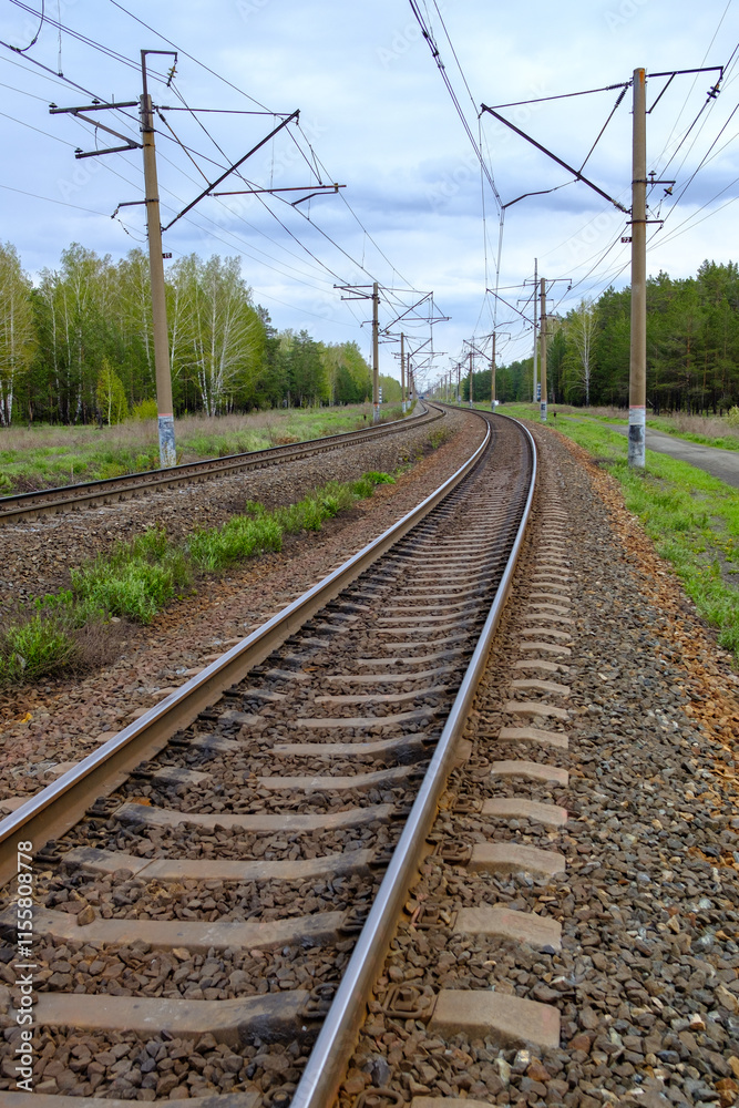 A train track with a few trees in the background A train track with a few trees in the background