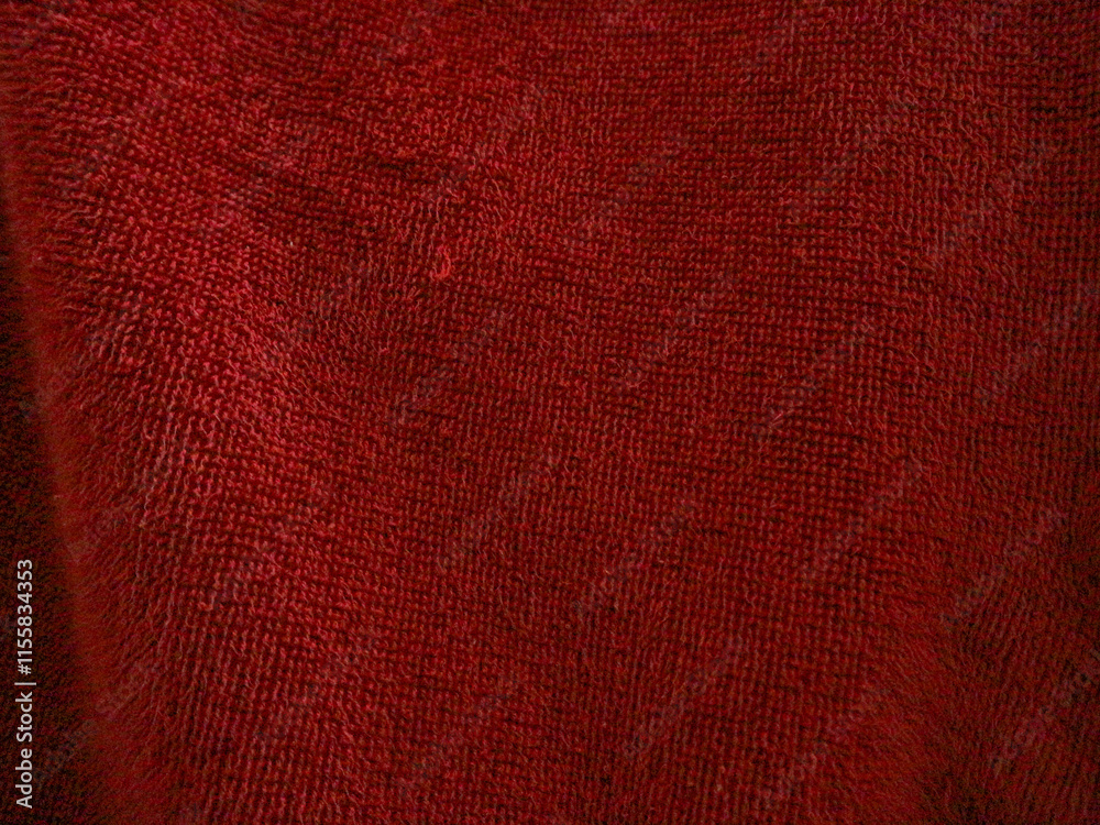 Fototapeta premium A close-up texture of red fabric, showing intricate fibers and a soft, plush surface, ideal as a background or textile detail.