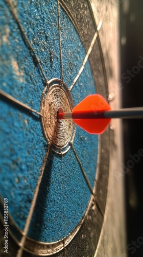 Dart hitting the bullseye on a blue dartboard at a local game room