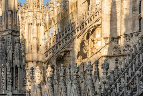 Gothic architecture of Milan Cathedral with spires, statues, pinnacles, flying buttresses and ornate balustrades, Milan, Lombardia, Italy. Close up of Duomo di Milano with detailed architecture photo