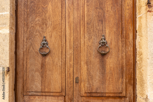 Capdepera, Mallorca, Spain 26.10.2021 Close-up of antique metal door knockers on wooden door panels showing fine detail