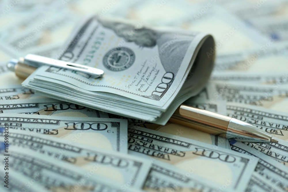 Golden pen clipping big amount of hundred dollar bills US banknotes Golden pen clipping big amount of hundred dollar bills US banknotes