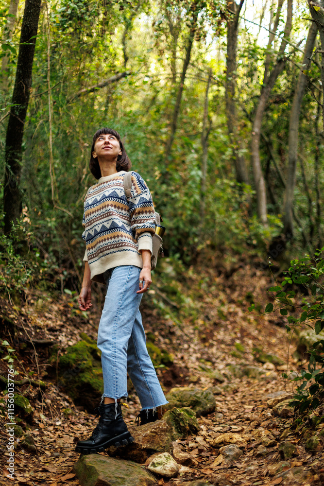 woman in a sweater and a backpack on her back travels. on a hike in the mountains. Young happy tourist woman relaxing in nature woman in a sweater and a backpack on her back travels. on a hike in the mountains. Young happy tourist woman relaxing in nature