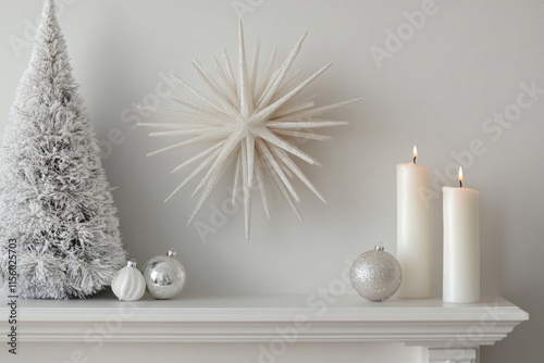 Elegant white Christmas mantel display with snowy tree, starburst, ornaments, and candles.