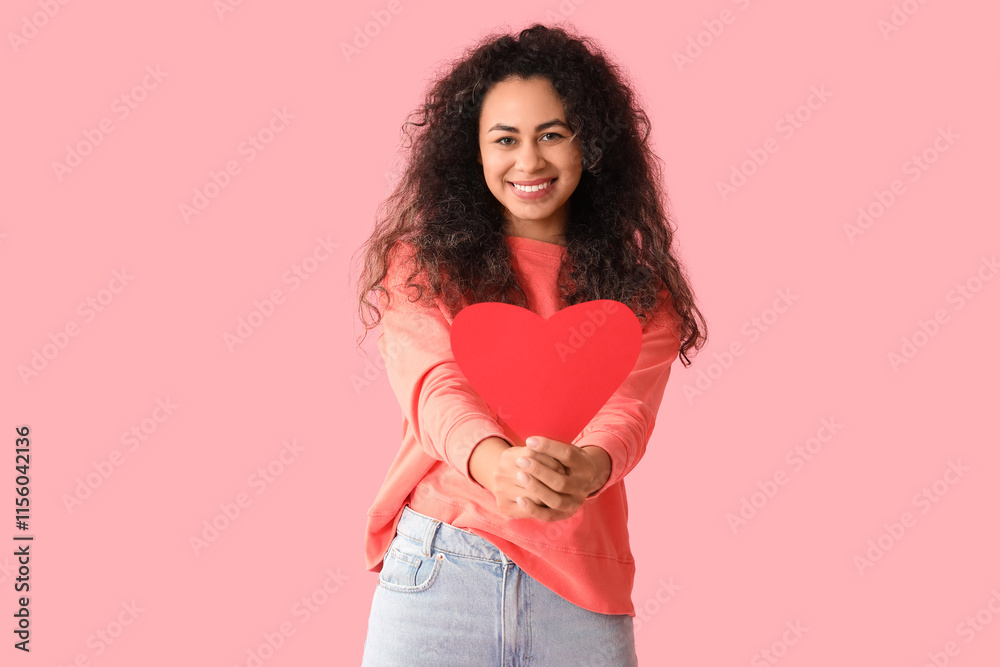 Beautiful young African-American woman with red paper heart on pink background Beautiful young African-American woman with red paper heart on pink background