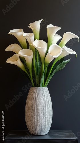 Elegant white calla lilies in a textured black vase against a dark background