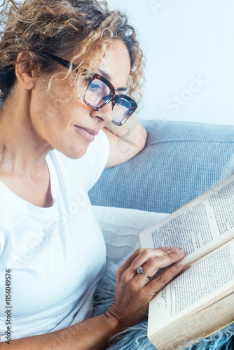 Photos Mature woman wearing glasses and curly hair, seated in a cozy home interior on a