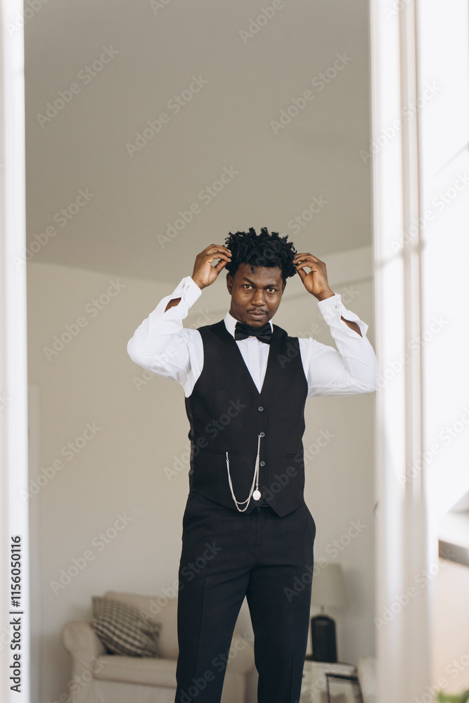 Elegant groom adjusting his hair while getting ready for wedding Elegant groom adjusting his hair while getting ready for wedding