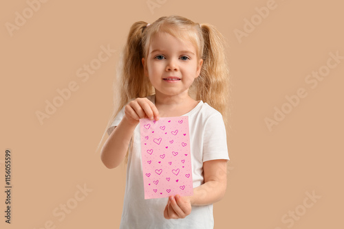 Cute little girl holding greeting card with hearts on beige background. Valentine's Day celebration