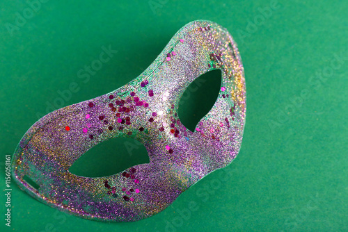 Shiny purple carnival mask for Mardi Gras celebration on green background photo