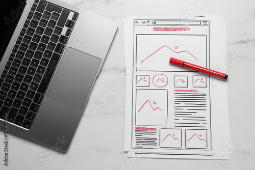 Developing UI design. Sketches of website wireframes, laptop and felt pen on white marble table, top view photo