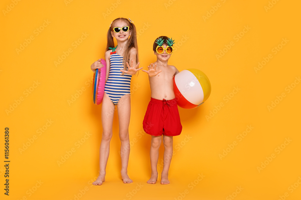Happy little kids in beachwear on orange background Happy little kids in beachwear on orange background