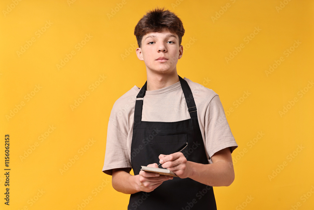 Boy with notepad taking order in cafe. Work for teenagers Boy with notepad taking order in cafe. Work for teenagers