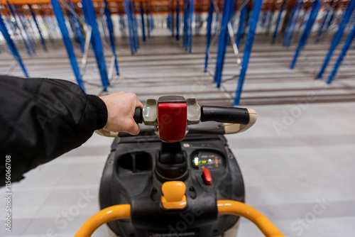 Electric pallet truck against the background of massive blue racks. Warehouse. photo