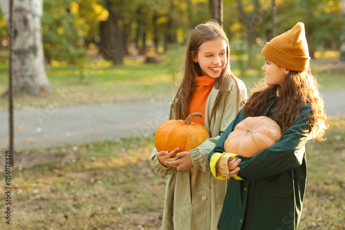 Cute girls with pumpkins in...