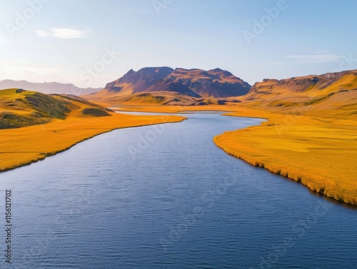 A stunning aerial view of the Jokulvisl glacial river flowing through vibrant yellow and orange fields, with majestic mountains in the background under a clear blue sky. photo