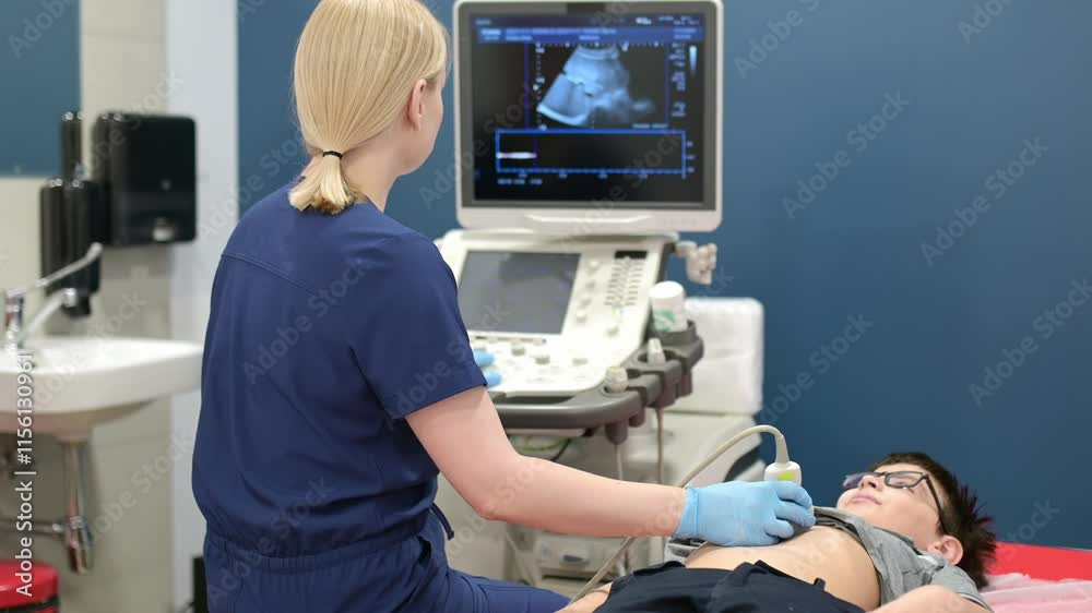 Doctor making abdominal ultrasound for boy using scanner machine ...