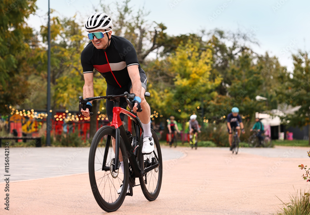 Fototapeta premium Group of athletic people riding bicycles outdoors, space for text