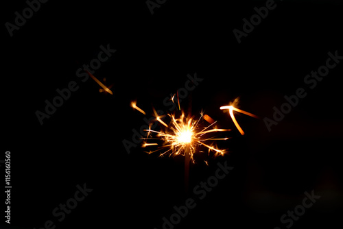 A sparkler is a type of hand held firework that burns slowly while emitting bright colored sparks photo