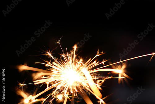 A sparkler is a type of hand held firework that burns slowly while emitting bright colored sparks photo