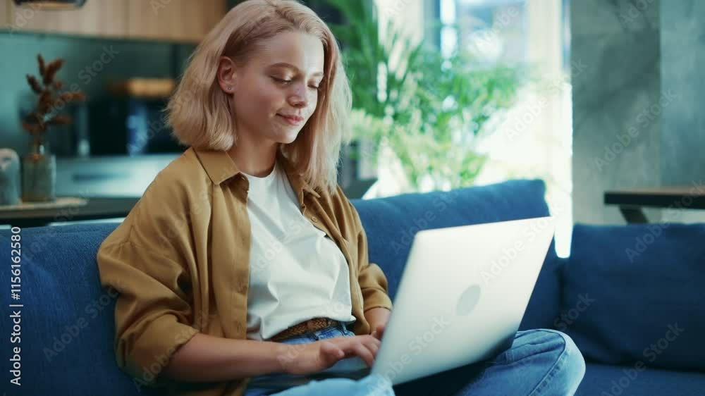 Young Woman Working Studying on Laptop in a Modern Living Room Young Woman Working Studying on Laptop in a Modern Living Room