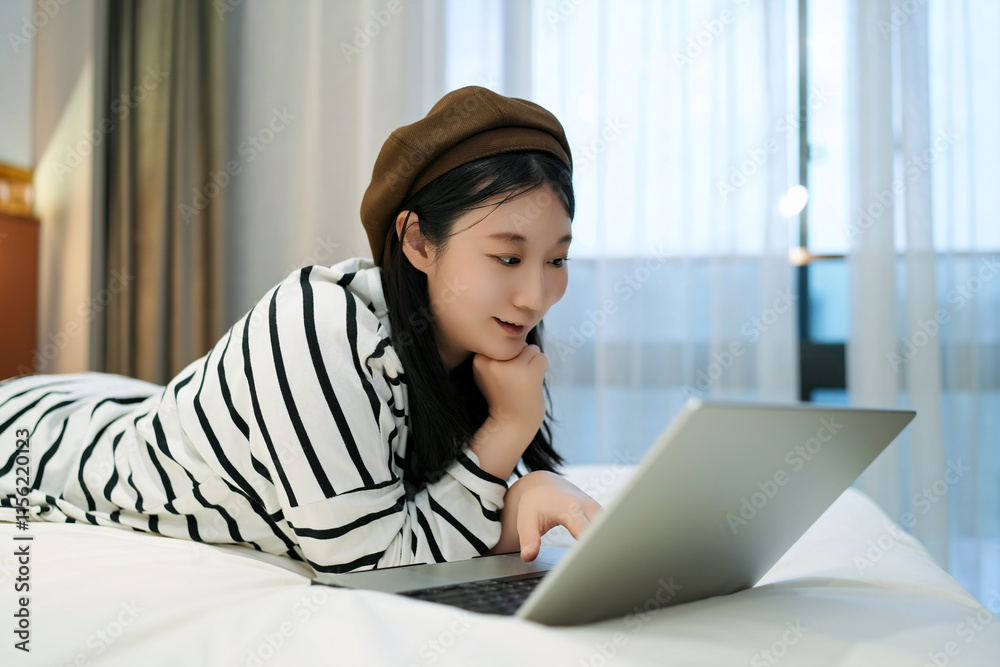 Cozy Evening at Home: Young Woman Engaged with Laptop in Casual Attire Cozy Evening at Home: Young Woman Engaged with Laptop in Casual Attire